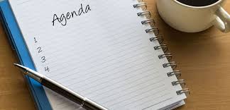 Agenda branca com caneta preta ao lado esquerdo 