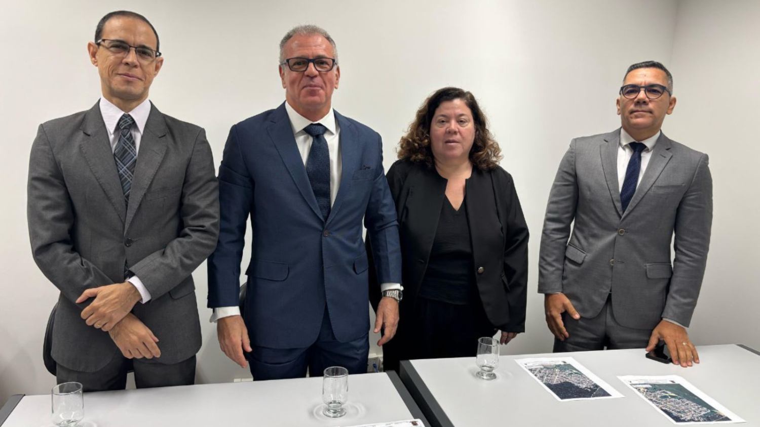 3 juízes e 1 juíza federal de pé por trás de duas mesas de escritório