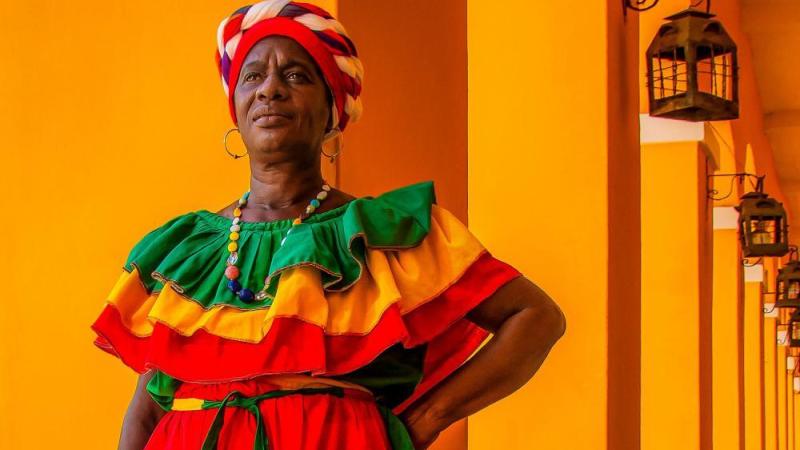 mulher preta vestindo roupas coloridas e turbante