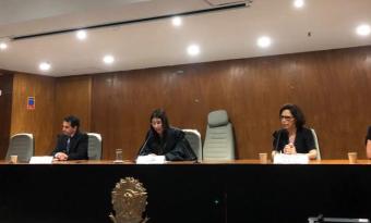 mulheres e homem brancos em mesa sentados lado a lado