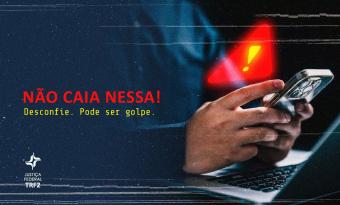 fundo escuro, uma mão branca segurando um celular, acima da mão o símbolo de atenção, letras no lado esquerdo na cor vermelha