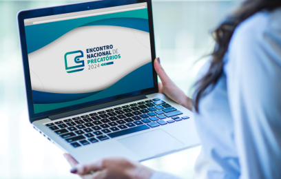 Imagem de uma mulher segurando um laptop. Na tela, o banner do Encontro Nacional de Precatórios 2024