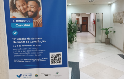 Banner azul da semana nacional da conciliação afixado no hall de entrada da sede da Justiça Federal, em Vitória