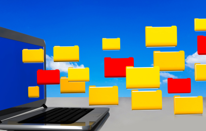 Imagem de notebook aberto, de cuja tela saem processos com capas amarelas e vermelhas