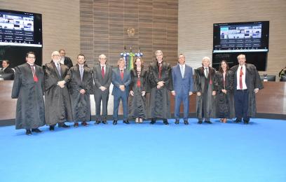 Rogério Tobias, de terno, no Plenário, ladeado por desembargadores, homens e mulheres, de toga. 