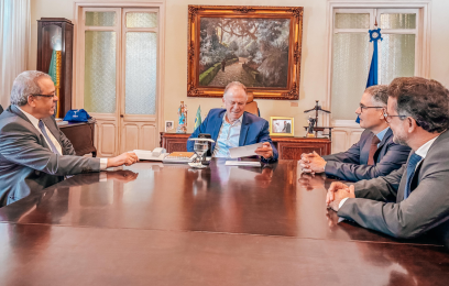 Reunião entre o governador, o presidente do TRF2, o diretor do foro e o procurador do Estado, em uma mesa retangular grande de madeira lustrosa