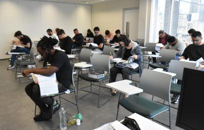 Sala com candidatos e candidatas fazendo a prova