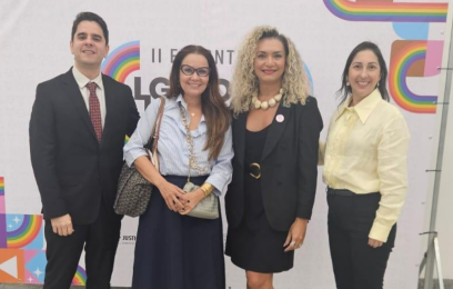 Um homem e três mulheres posam sorrindo para a foto