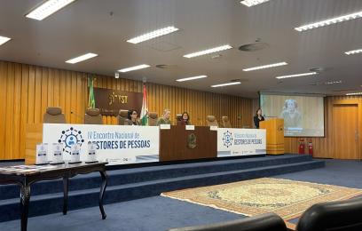 mesa do evento com banner branco e letras azuis